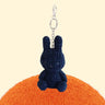 Four officially licensed Miffy textured tweed plush keychains lined up in pink, sage green, cream, and navy blue with attached silver keyrings