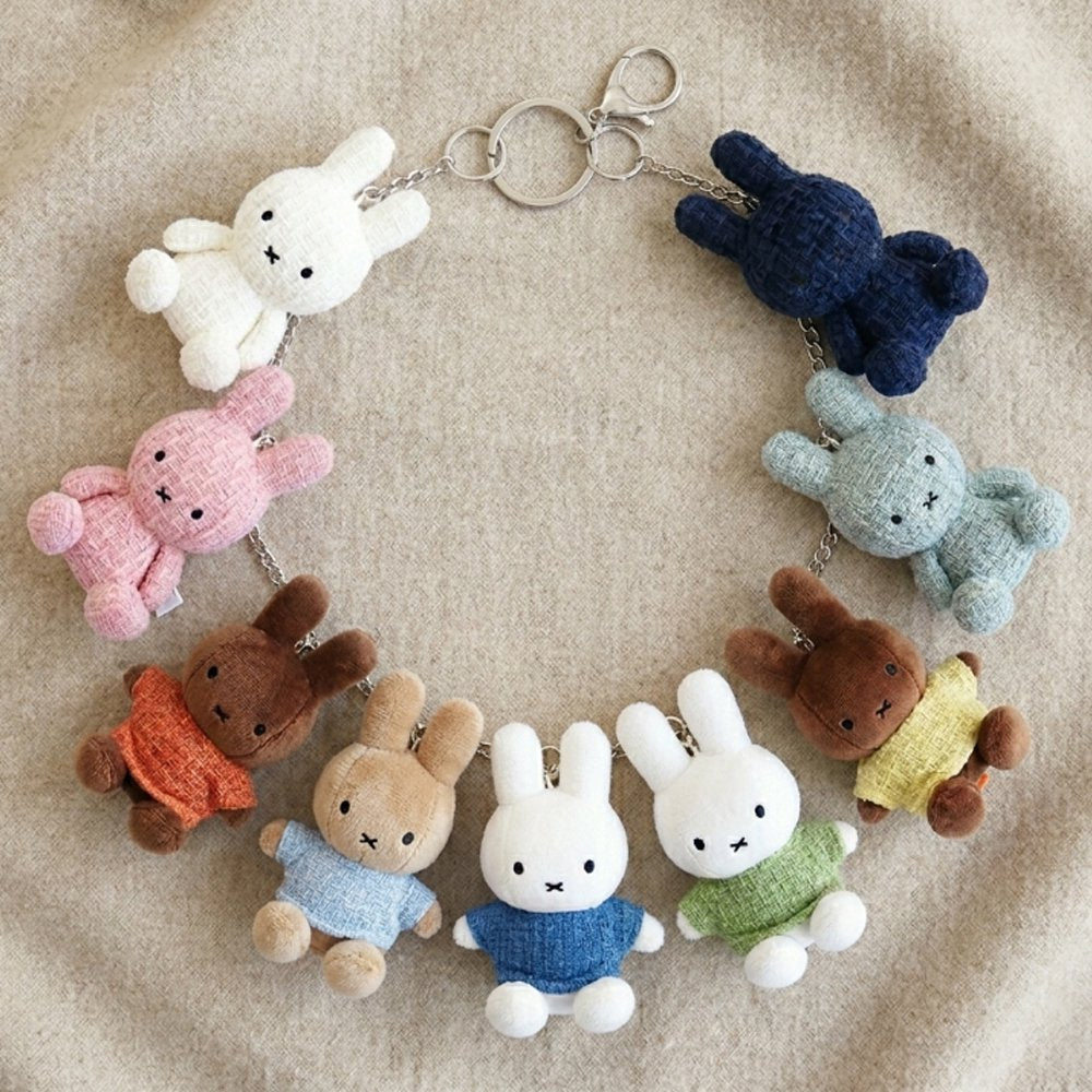 Officially licensed Miffy textured tweed plush keychains lined up in cream, pink, orange, sky blue, blue, green, yellow, mint green, and navy with attached silver keyrings