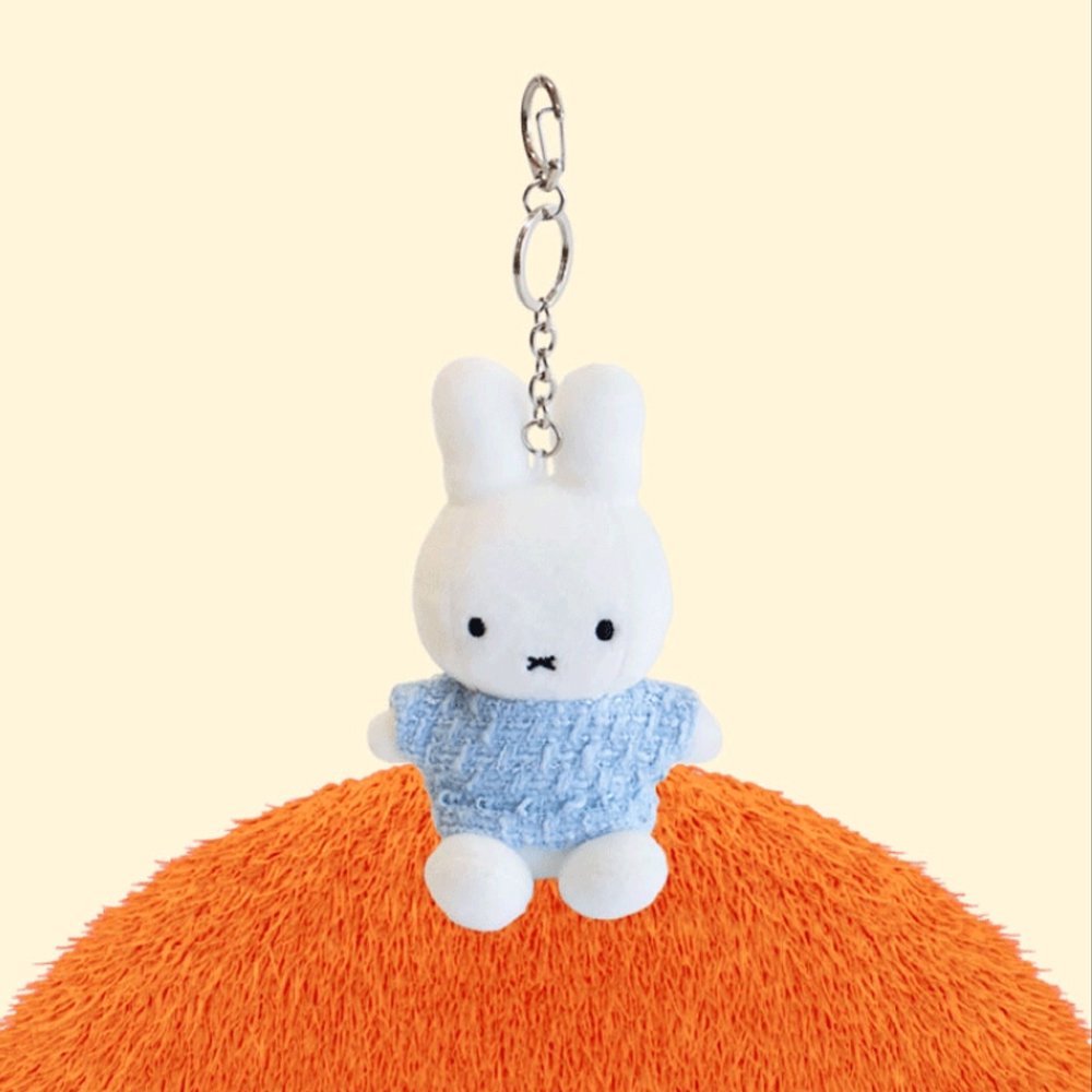 Four officially licensed Miffy plush keychains wearing knit sweaters in orange, green, light blue, and dark blue standing together. Each plush includes an attached silver chain with a lobster clasp at the top.
