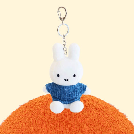 Four officially licensed Miffy plush keychains wearing knit sweaters in orange, green, light blue, and dark blue standing together. Each plush includes an attached silver chain with a lobster clasp at the top.