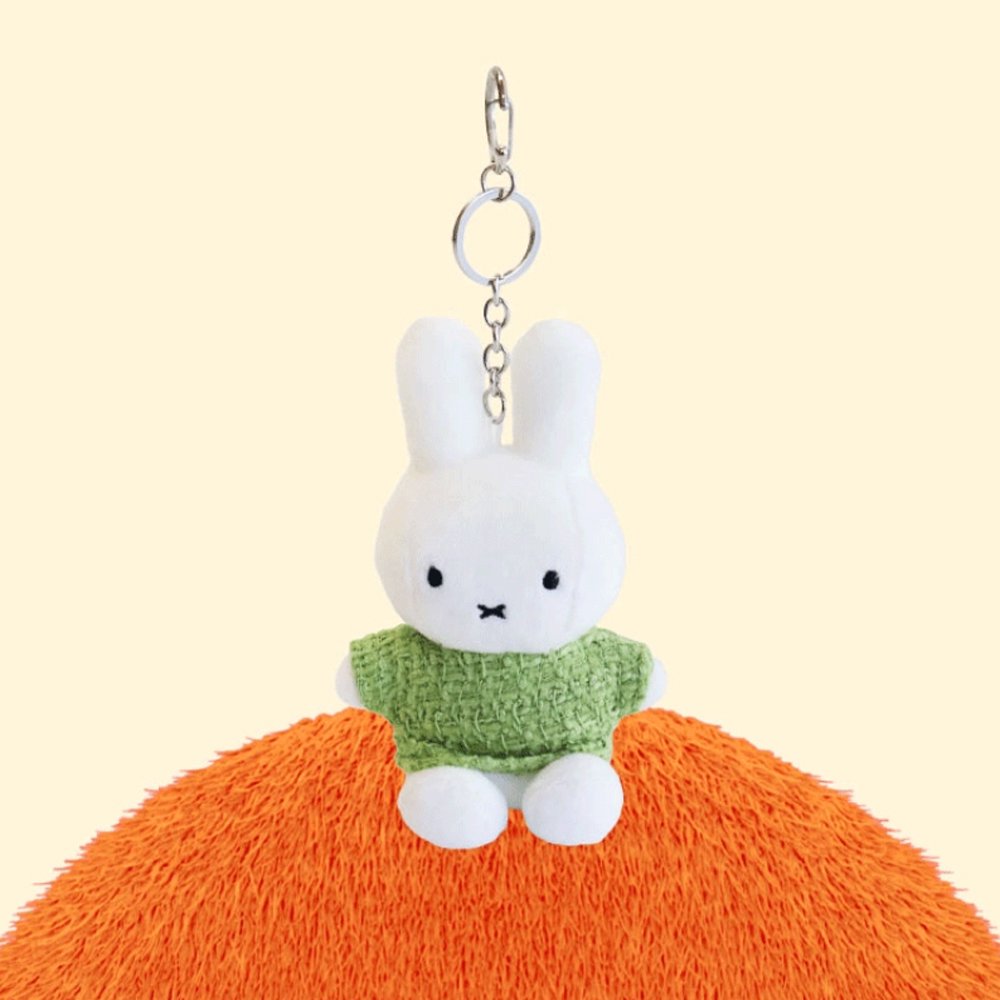 Four officially licensed Miffy plush keychains wearing knit sweaters in orange, green, light blue, and dark blue standing together. Each plush includes an attached silver chain with a lobster clasp at the top.