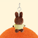 Four officially licensed Miffy plush keychains wearing knit sweaters in orange, green, light blue, and dark blue standing together. Each plush includes an attached silver chain with a lobster clasp at the top.