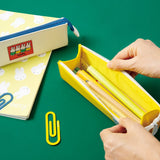 Two officially licensed slim, triangular Miffy pencil cases, featuring one in bright yellow with a white zipper and a "miffy & dan" patch, and the other in cream-colored with a bold blue zipper and a red "miffy" patch.
