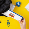 Two officially licensed slim, triangular Miffy pencil cases, featuring one in bright yellow with a white zipper and a "miffy & dan" patch, and the other in cream-colored with a bold blue zipper and a red "miffy" patch.
