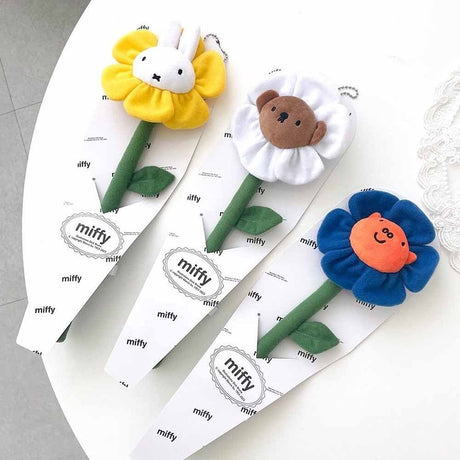 A collection of Miffy Friends Flower Plushies stuffed animals in various colors, each designed to look like a flower with animal faces in the center.
