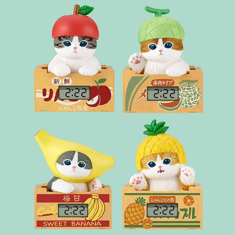 Four Mofusand cat-shaped digital clocks with fruit designs on a light green background
