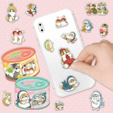 An officially licensed Mofusand sticker set in an orange and yellow tin shaped like a cat food can. The label features a kitten playing with a green grape and a window showing several fruit-themed cat stickers inside.