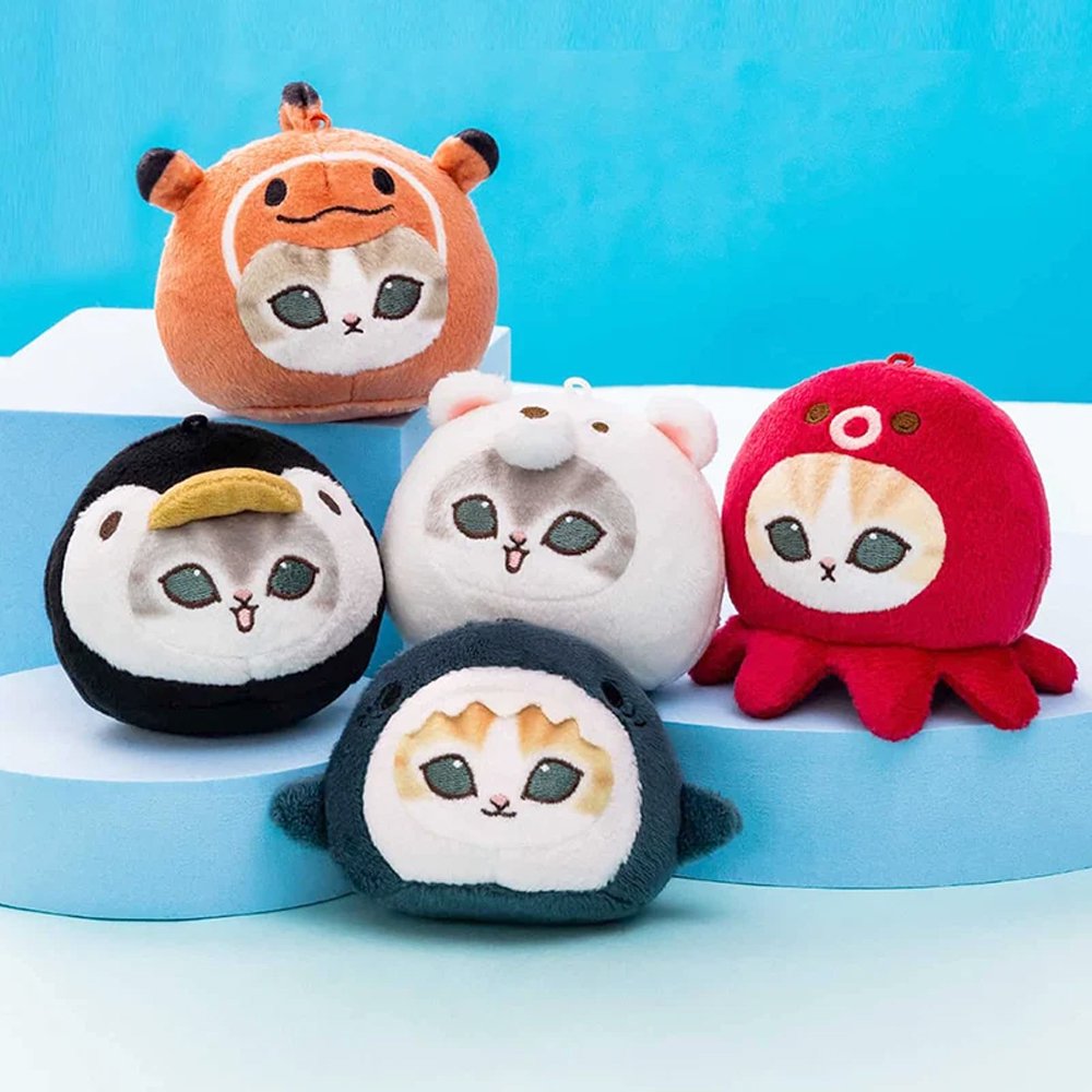 Five officially licensed Mofusand round plush cat keychains wearing sea creature costumes, including a red octopus, dark blue shark, black penguin, orange otter, and white polar bear. Each soft plush charm includes a gold ball chain at the top
