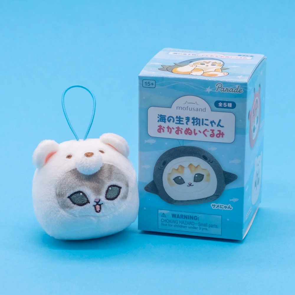 Five officially licensed Mofusand round plush cat keychains wearing sea creature costumes, including a red octopus, dark blue shark, black penguin, orange otter, and white polar bear. Each soft plush charm includes a gold ball chain at the top