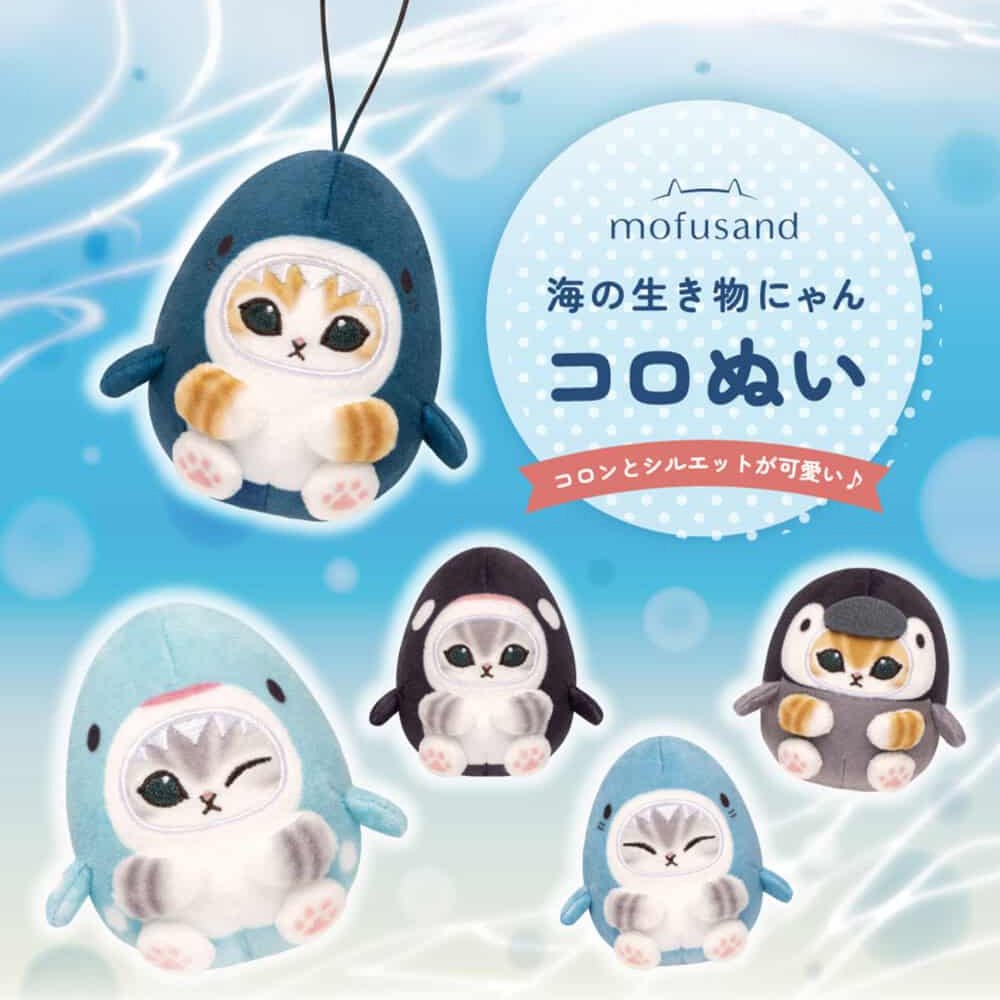 Five officially licensed Mofusand plush keychains featuring small cats wearing various marine animal costumes like blue sharks, a black orca, and a grey penguin. The cats are depicted with cute expressions, including one winking and one with its eyes closed in a happy smile.