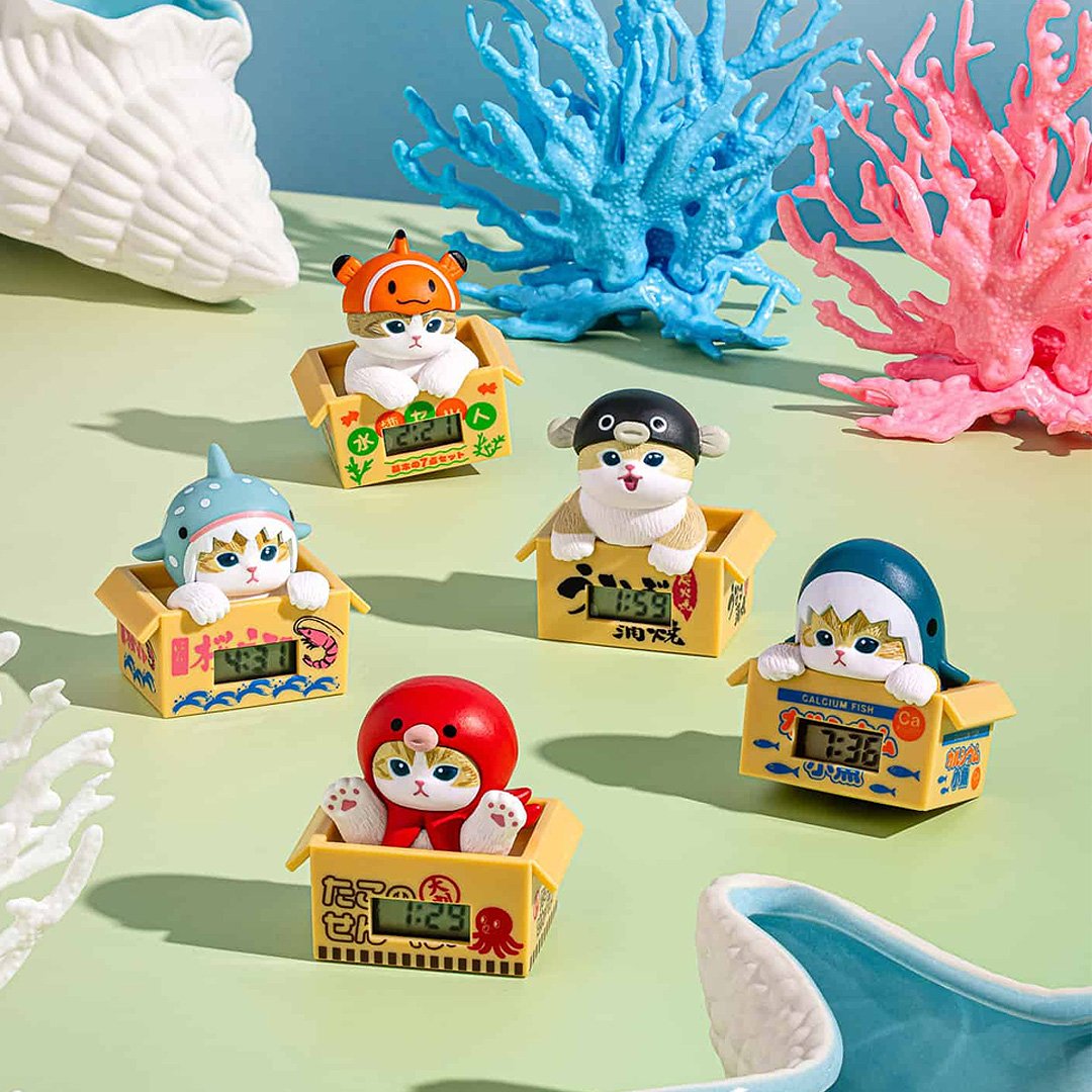 Collectible mofusand cat clocks featuring various costumes like a shark, tuna, and octopus, presented in mini crates as a blind box series with digital time.