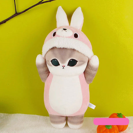 An officially licensed Mofusand plush toy of a grey tabby cat wearing a pink bunny rabbit costume with its paws raised over its head