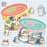 An officially licensed Mofusand sticker set packaged in a pink and teal tin designed to look like a cat food can. A clear window on the front reveals several die-cut stickers of cats in shark costumes, with "30 pieces" and "Fresh Cuteness 100%" printed on the label.
