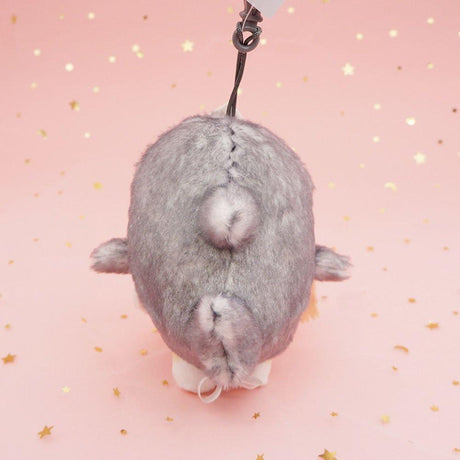 An officially licensed Mofusand shark cat plush keychain featuring a fluffy cream tabby kitten wearing a gray shark onesie with embroidered details