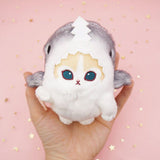 An officially licensed Mofusand shark cat plush keychain featuring a fluffy cream tabby kitten wearing a gray shark onesie with embroidered details