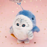 An officially licensed Mofusand shark cat plush keychain featuring a fluffy gray tabby kitten wearing a blue shark onesie with embroidered details