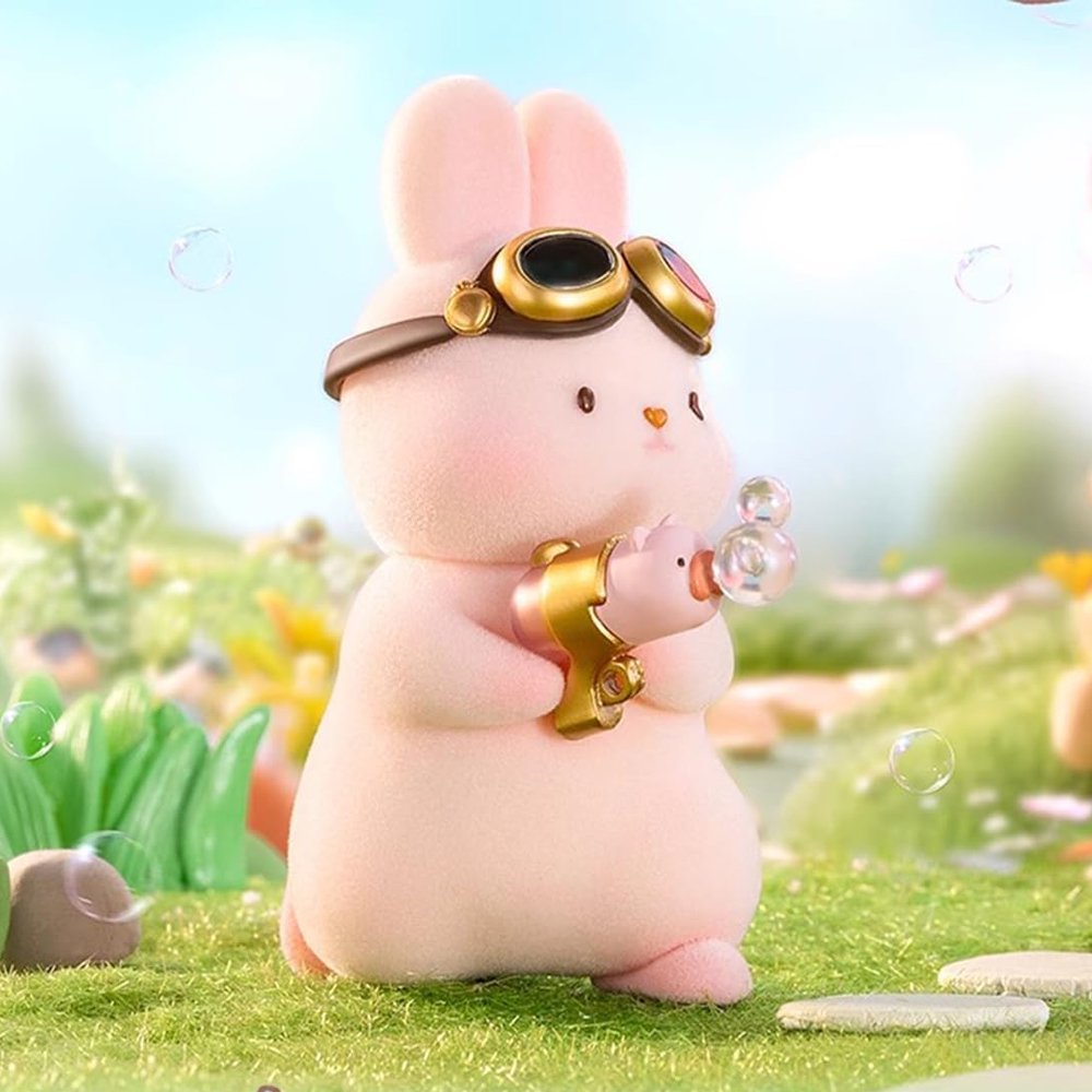 A group of officially licensed Momo Bunny Strawberry Town figures displayed in a miniature outdoor garden setting. The pink bunnies are dressed in various cute outfits, including a snowman suit, a pilot cap, and one sitting inside a strawberry-patterned teacup.
