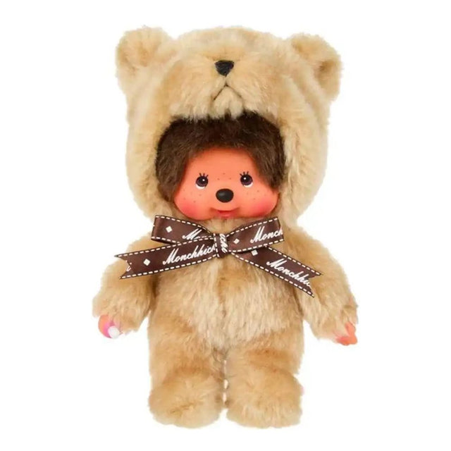 Officially licensed Monchhichi plush doll wearing a fuzzy, light beige teddy bear costume with a hood. The doll features a detailed vinyl face with rosy cheeks and is adorned with a brown ribbon tied around its neck reading "Monchhichi" in white text.
