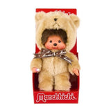 Officially licensed Monchhichi plush doll wearing a fuzzy, light beige teddy bear costume with a hood. The doll features a detailed vinyl face with rosy cheeks and is adorned with a brown ribbon tied around its neck reading "Monchhichi" in white text.
