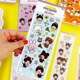 A vertical sheet of officially licensed Monchhichi stickers by Pipsticks on a light blue background, featuring various winged Monchhichi characters, golden hearts, harps, and floral accents