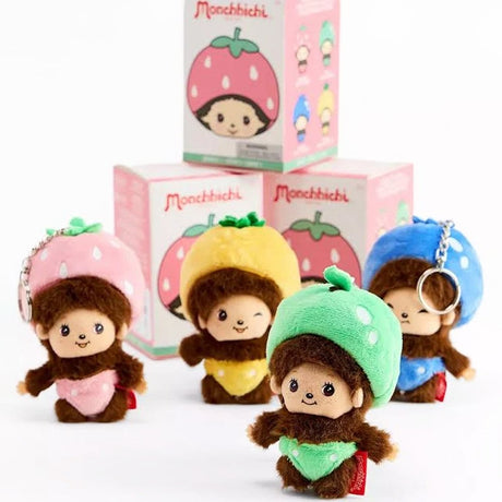 A group of four officially licensed Monchhichi plush keychains dressed in colorful fruit costumes—pink strawberry, yellow lemon, green lime, and blue berry. Each small plush features a metal keychain ring attached to its head.