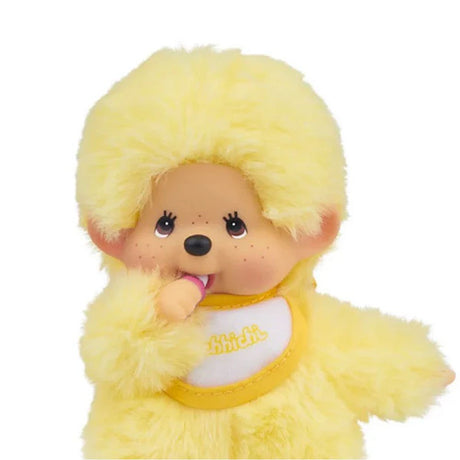 Officially licensed Monchhichi plush , shown against a white background. The plush dolls are yellow with fluffy bodies, ABS faces, and are posed sucking his thumbs. They each wear a small embroidered bib.