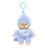 Officially licensed Monchhichi plush keychain doll featuring soft pastel blue fur and a matching light blue plastic clip attached to its head. The doll has a freckled vinyl face and wears a shiny blue satin bib with a white lace border reading "Monchhichi".
