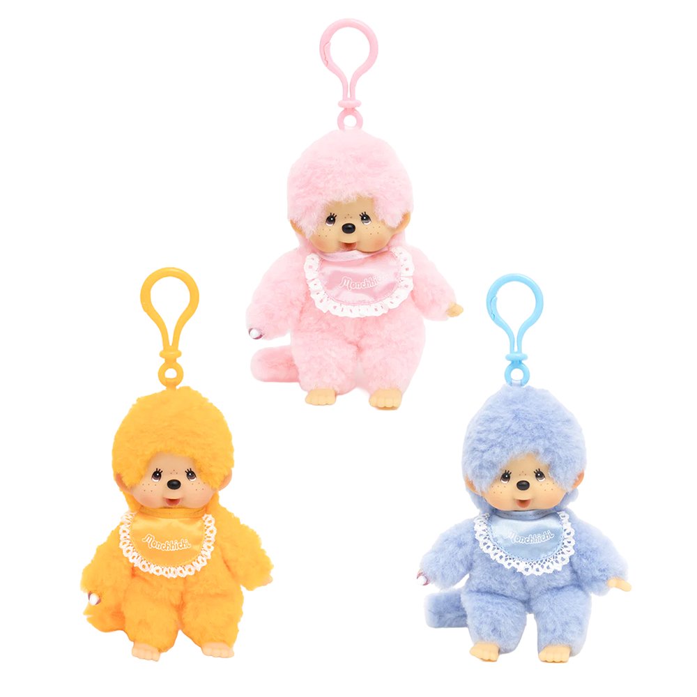 Officially licensed Monchhichi plush keychain doll collection featuring soft pastel color fur and a matching plastic clip attached to its head. Each doll has a freckled vinyl face and wears a shiny satin bib with a white lace border reading "Monchhichi".
