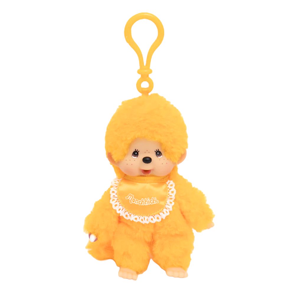 Officially licensed Monchhichi plush keychain doll featuring vibrant orange fur and a matching orange plastic clip attached to its head. The doll has a freckled vinyl face and wears a shiny orange satin bib with a white lace border reading "Monchhichi".
