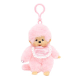 Officially licensed Monchhichi plush keychain doll featuring soft pastel pink fur and a matching pink plastic clip attached to its head. The doll has a freckled vinyl face and wears a shiny pink satin bib with a white lace border reading "Monchhichi".
