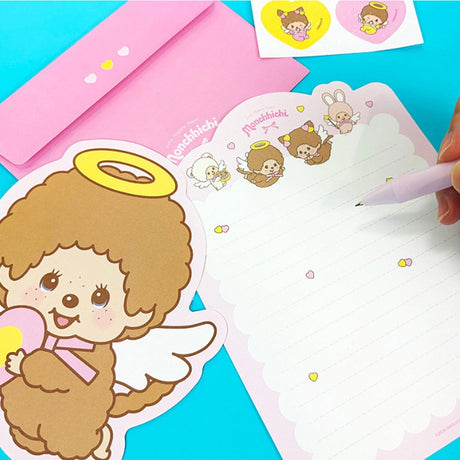 An officially licensed Monchhichi letter writing set displayed with die-cut stationary paper in pink and yellow themes, matching envelopes, and heart sealing stickers