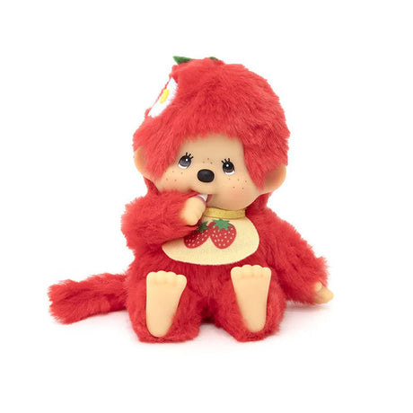 An officially licensed, bright red, strawberry-themed Monchhichi plush doll with a ABS face, a strawberry-print bib, and a green stem ,flower detail on its head, and is posed sucking its thumb