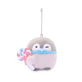 Officially licensed Spiralcute Koupen Chan plush mascot keychain featuring a winking cute grey penguin with rosy pink cheeks wearing a light blue bow tie and holding a colorful pink, white, and blue swirl lollipop candy with a pink ribbon bow, attached to a silver ball chain. Perfect for adult kidult collectors as a cute aesthetic bag charm or collectible key ring.