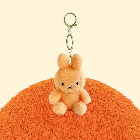 Official Miffy Creamy Mascot Plush Keychains in  warm orange. These fluffy-textured mini miffy dolls feature a durable gold-tone clip, making them perfect aesthetic bag accessories for adult collectors. An ideal nostalgic gift that provides visual rest and minimalist zen for daily use.