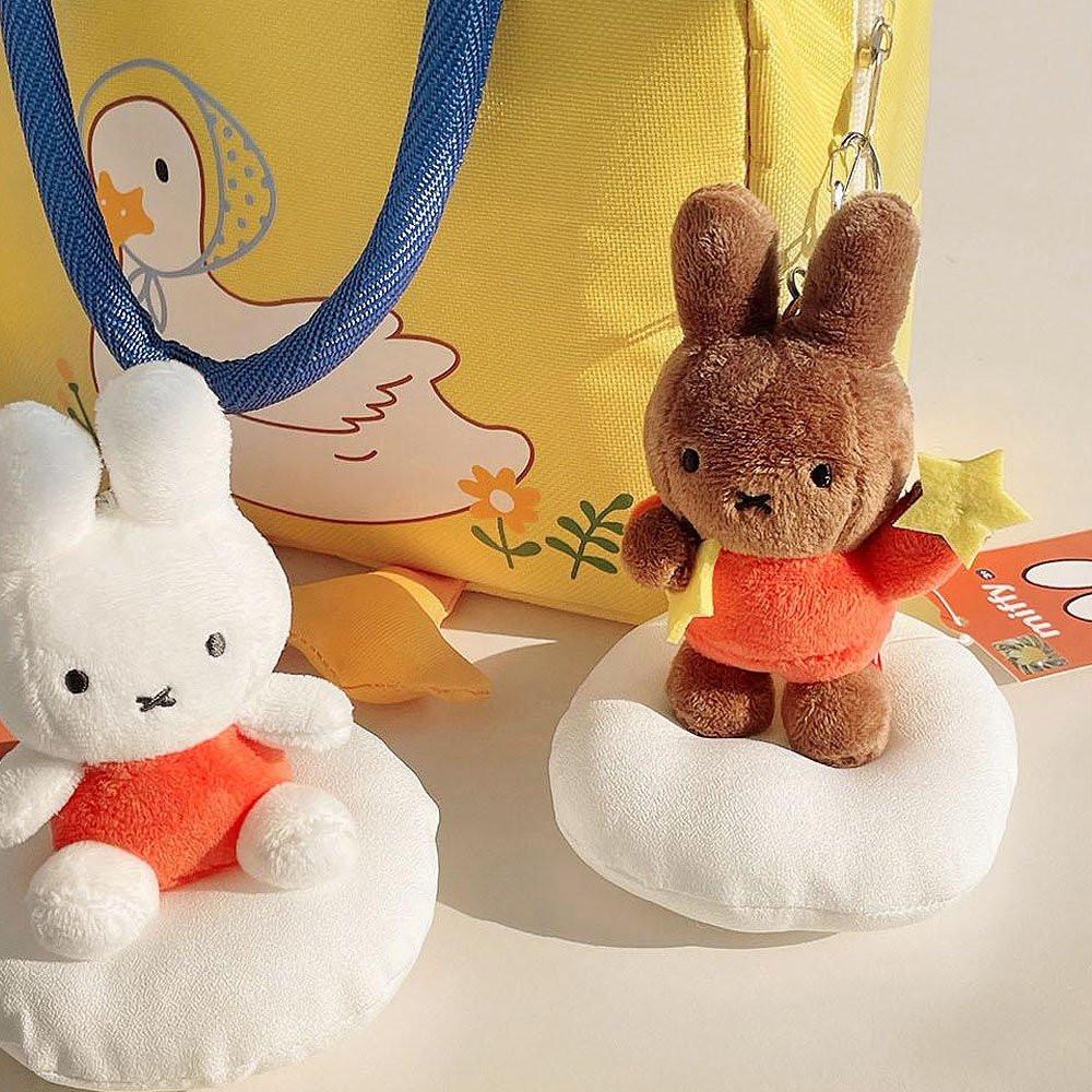 Official Miffy and Melanie Dream Mascot Plush Keychains displayed with a yellow tote bag; featuring white Miffy and brown Melanie in orange outfits holding stars, a nostalgic minimalist Zen bag charm set for adult friendship gifts and office-core aesthetics.