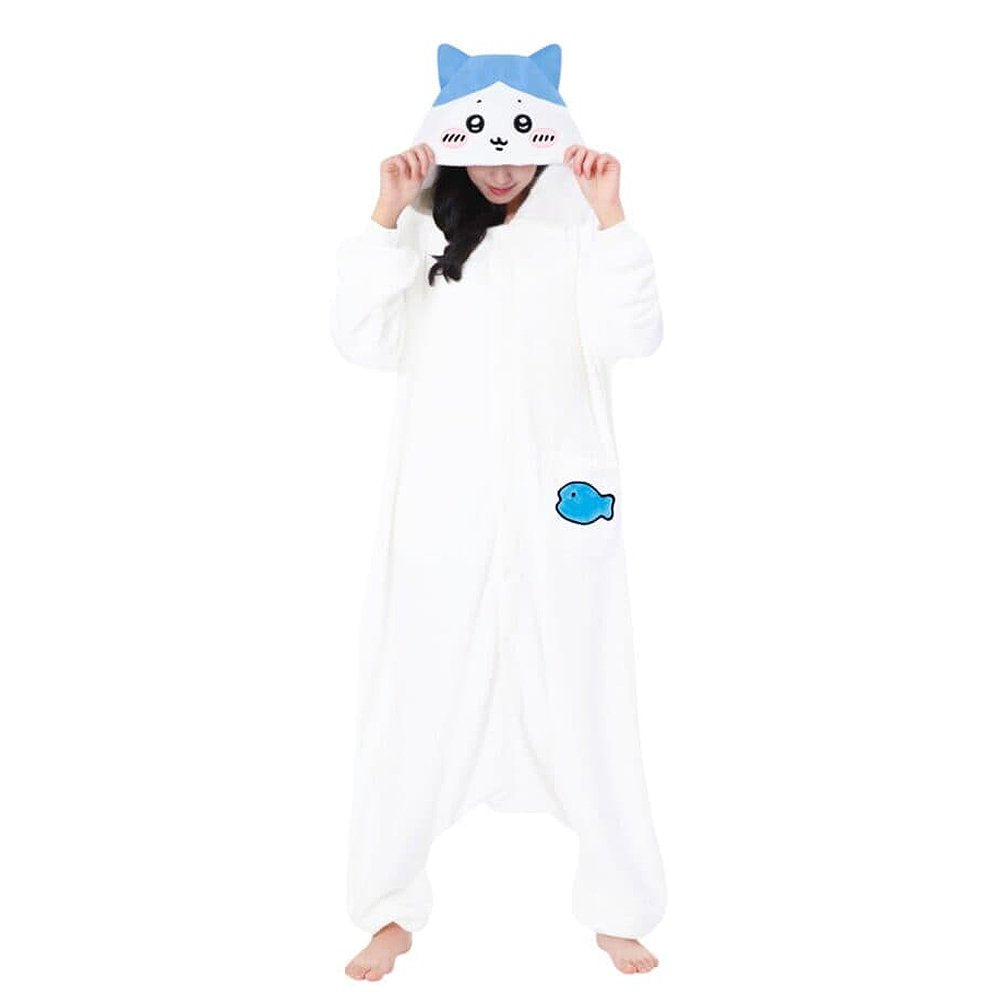 front view of the Official SAZAC Chiikawa Hachiware Kigurumi Vol. 2 Costume Onesie Jumpsuit worn by a model. Features a soft white fleece body, Hachiware face hood with blush details, and the upgraded blue fish pochette pocket embroidery. Perfect for Halloween costumes, cozy sleepover nights, and cosplay party loungewear for anime fans