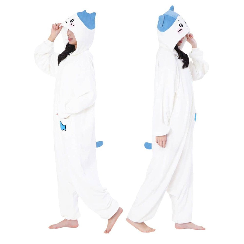 Official SAZAC Chiikawa Hachiware Kigurumi Vol. 2 Costume Onesie Jumpsuit worn by a model. Features a soft white fleece body, Hachiware face hood with blush details, and the upgraded blue fish pochette pocket embroidery. Perfect for Halloween costumes, cozy sleepover nights, and cosplay party loungewear for anime fans