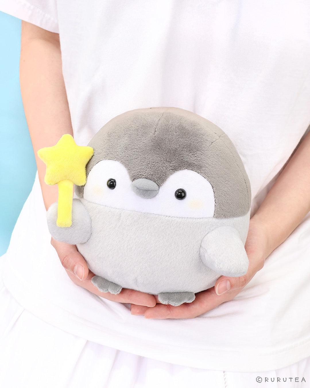Official Spiralcute Koupen Chan Star Wand Plush held in hand; featuring the positive penguin with a yellow star wand against a dreamy blue sky background. A premium nostalgic aesthetic for adult mental wellness, perfect for graduation gifts, "get well soon" surprises, and office-core healing decor for dedicated collectors.