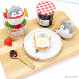 Official Spiralcute Koupen Chan Bakery Series Plush Mascot Keychain Collection featuring a chef penguin with a rolling pin in a strawberry glass bowl, a penguin inside a buttered toast costume on a white plate, and a winking penguin holding a baguette, arranged on a wooden cutting board with a jam jar to serve as a comforting workplace healing companion and emotional support tool for adult kidult collectors.