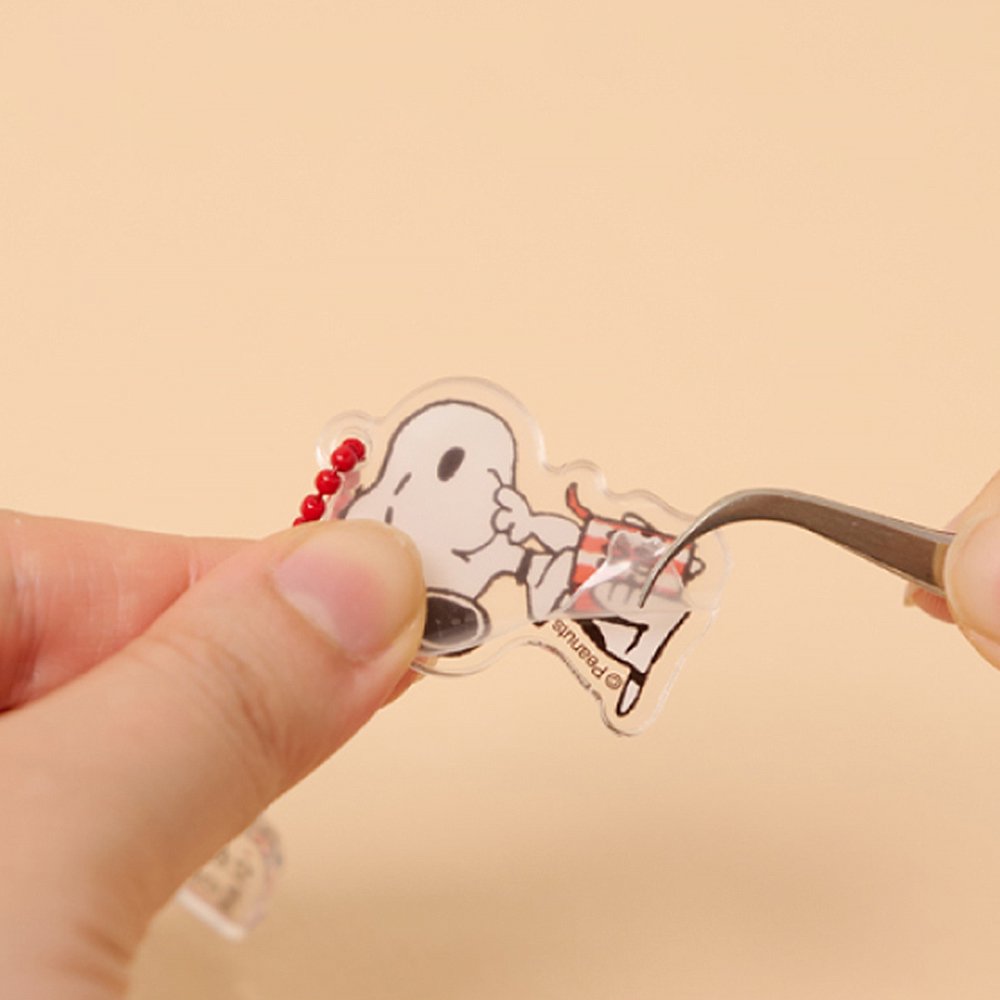 A collection of 12 different Peanuts character acrylic keychains in "Luck For You" blind boxes. The keychain features Snoopy.