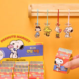 A collection of 12 different Peanuts character acrylic keychains in "Luck For You" blind boxes. The keychains feature Snoopy, Woodstock, Charlie Brown, Lucy.