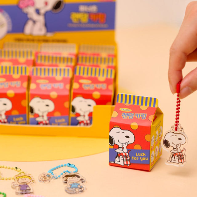 A collection of 12 different Peanuts character acrylic keychains in "Luck For You" blind boxes. The keychains feature Snoopy, Woodstock, Charlie Brown, Lucy, Linus, and Sally.