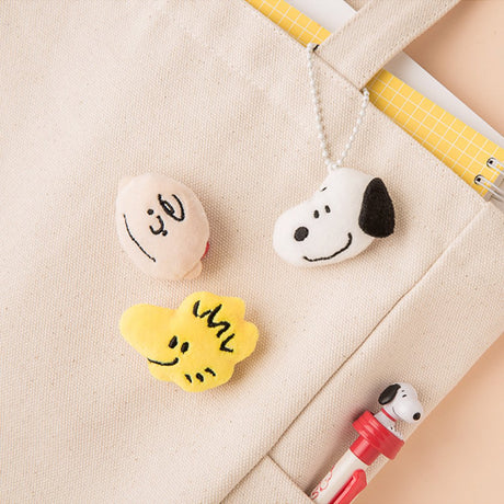 Officially licensed Peanuts plush keychains featuring the faces of Snoopy, Charlie Brown, and Woodstock attached to a white ball chain.