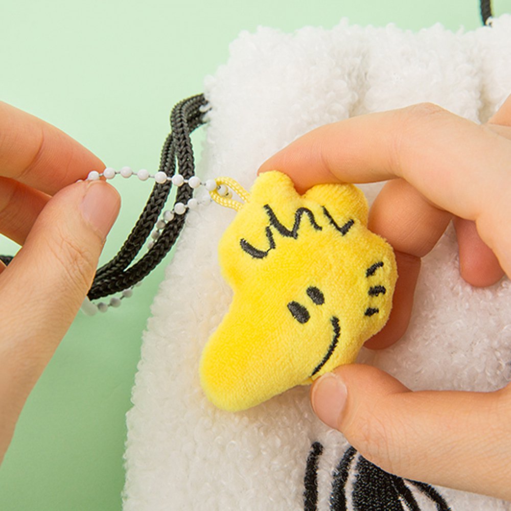 Officially licensed Peanuts plush keychains featuring the faces of Snoopy, Charlie Brown, and Woodstock attached to a white ball chain.