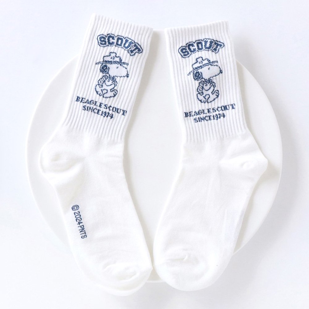 A set of five crew-length socks in black, beige, white, green, and mustard yellow. Each sock features an embroidered graphic of Snoopy as a Beagle Scout leader.
