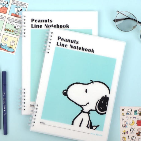 Three officially licensed Peanuts line notebooks with translucent covers in soft hues of pink, yellow, and green, each featuring a large illustration of Snoopy. The interior view shows 8mm ruled pages with small Snoopy graphics at the top and bottom corners.
