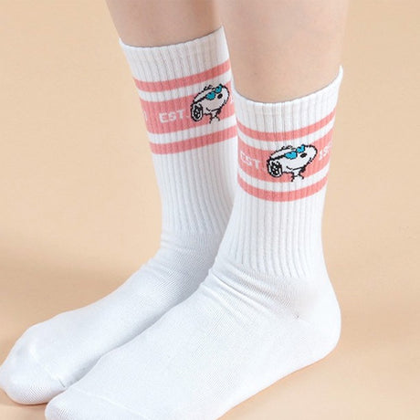 A set of five athletic crew socks in colored stripes of black, pink, green, light blue, and white. Snoopy's face wearing matching colored caps. All socks feature "EST. 1950" text and "SNOOPY" branding on the soles.
