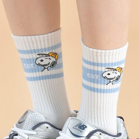 A set of five athletic crew socks in colored stripes of black, pink, green, light blue, and white. Snoopy's face wearing matching colored caps. All socks feature "EST. 1950" text and "SNOOPY" branding on the soles.