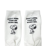 A set of three crew-length socks in white, beige, and black, celebrating Snoopy's 75th anniversary. Features clean, line-art illustrations of Snoopy and Woodstock in their most recognizable poses.