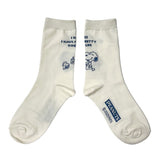 A set of three crew-length socks in white, beige, and black, celebrating Snoopy's 75th anniversary. Features clean, line-art illustrations of Snoopy and Woodstock in their most recognizable poses.